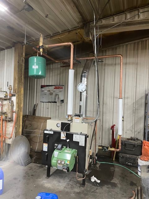 A green tank is hanging from the ceiling above a boiler