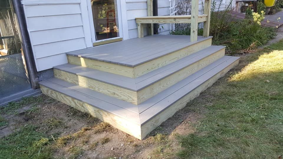 Wooden deck with three steps leading to a house entrance