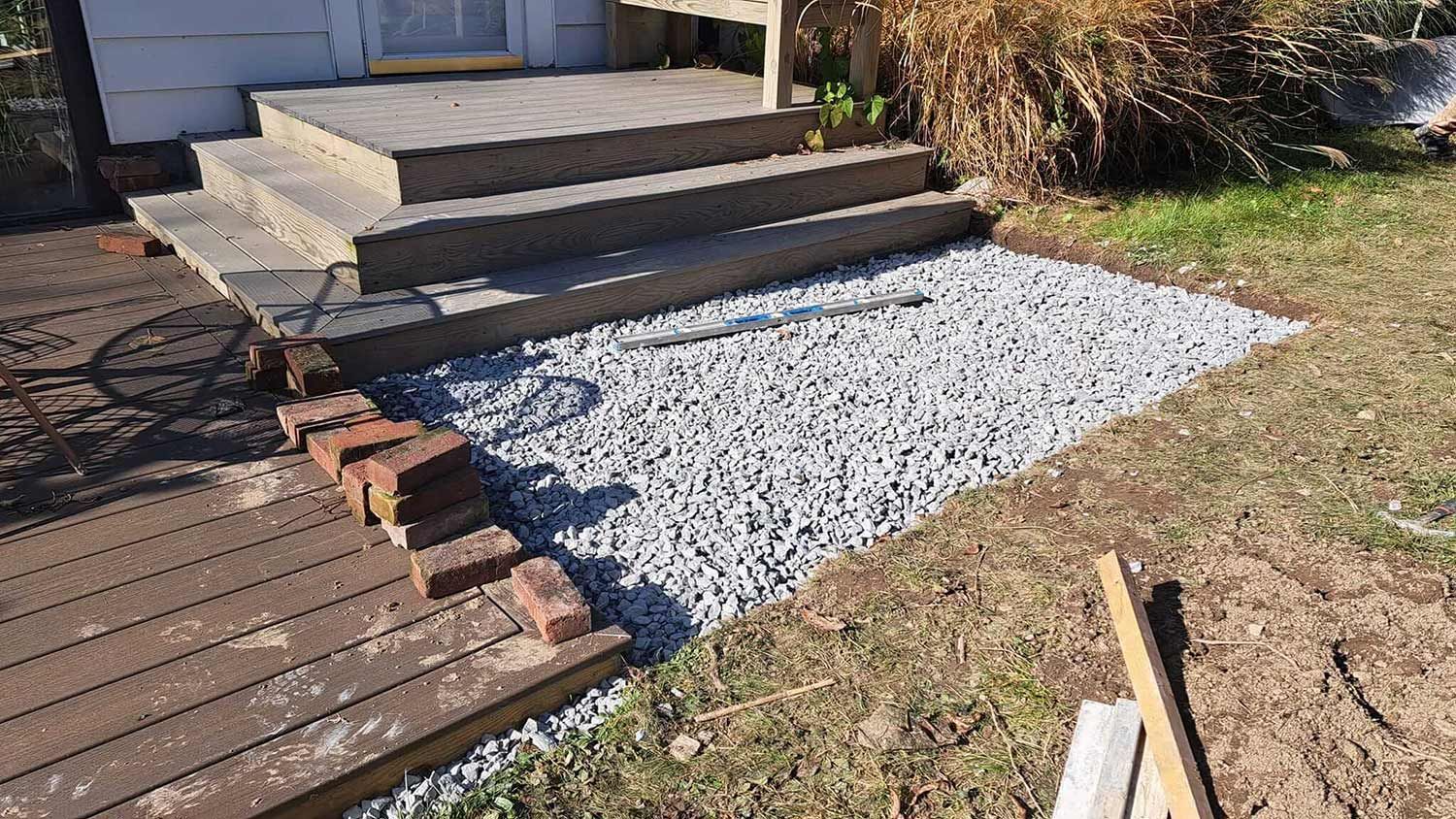 Gravel pathway beside wooden porch steps