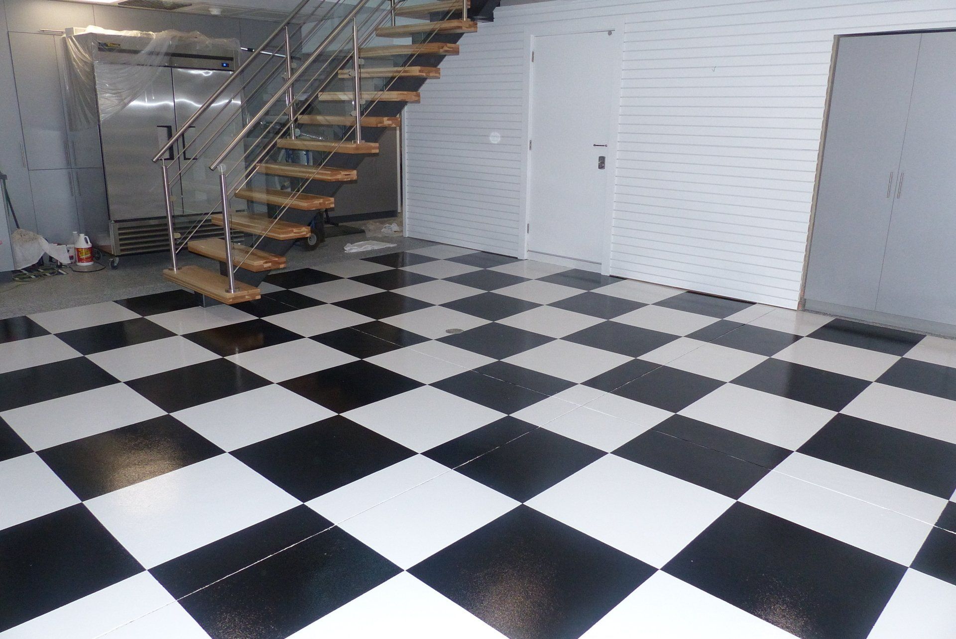 Un sol à carreaux noir et blanc avec un escalier en arrière-plan