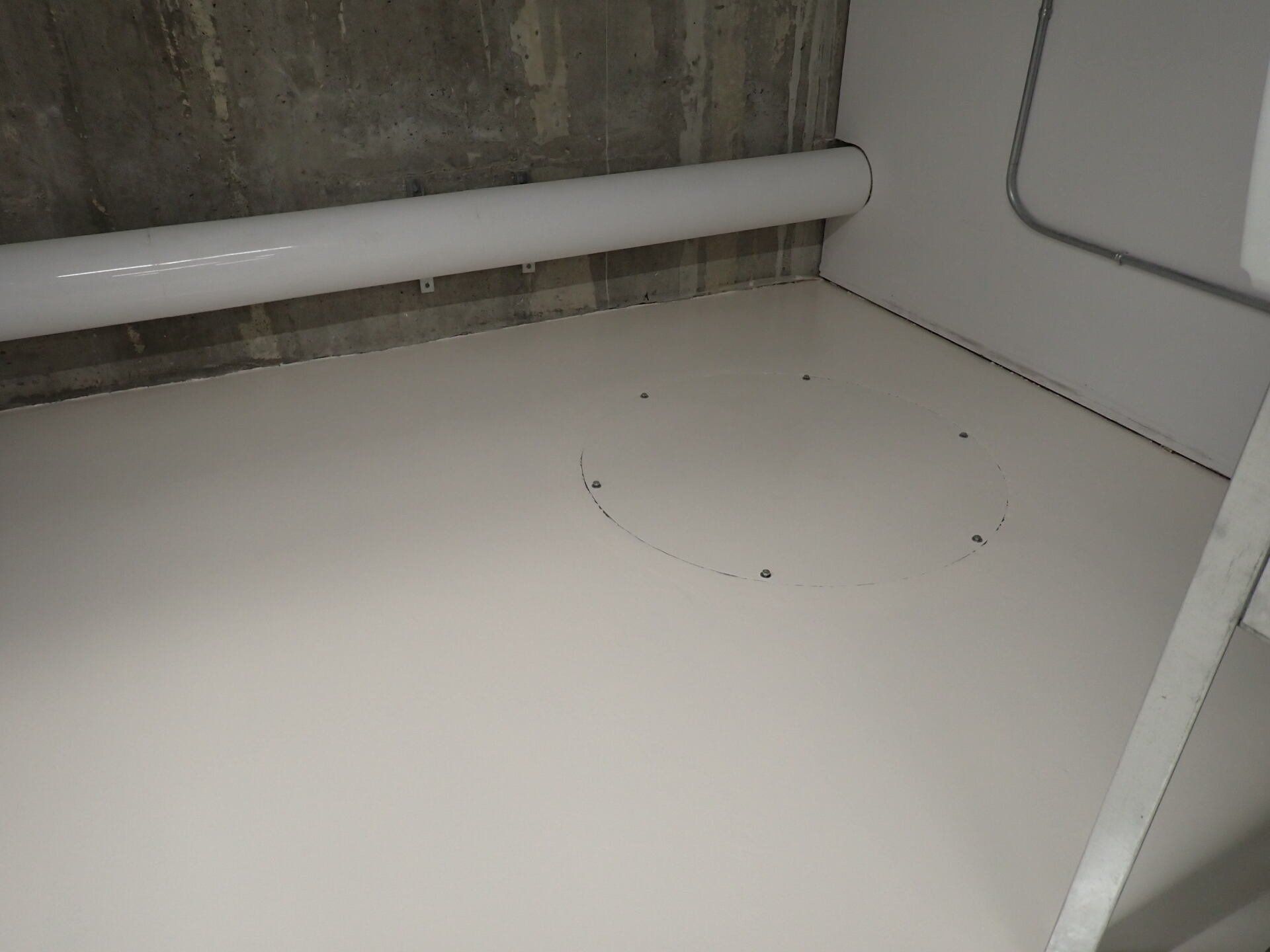 Un sol blanc avec un trou au milieu dans une pièce.