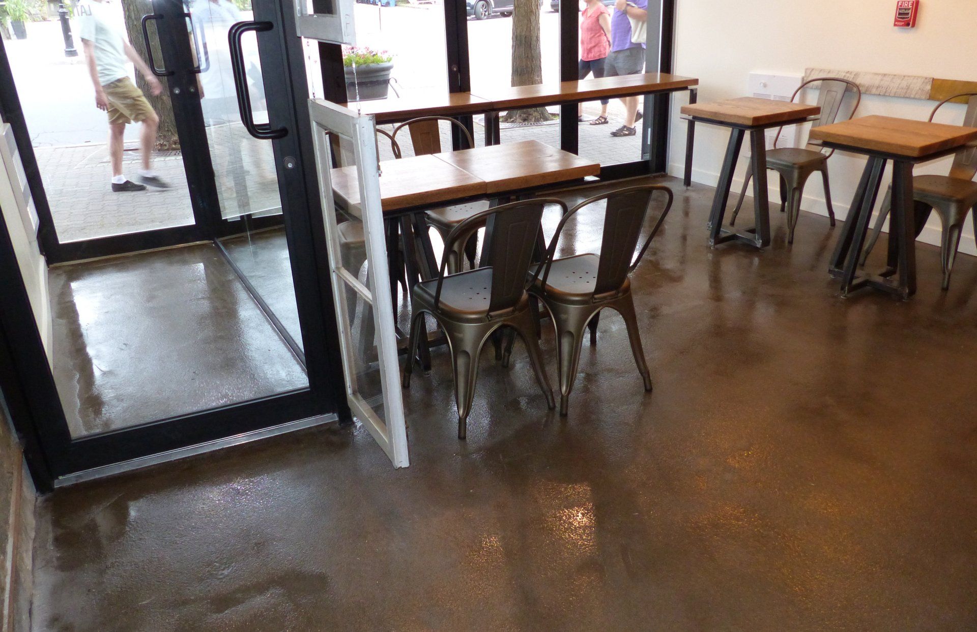 Un restaurant avec des tables et des chaises devant une porte vitrée.