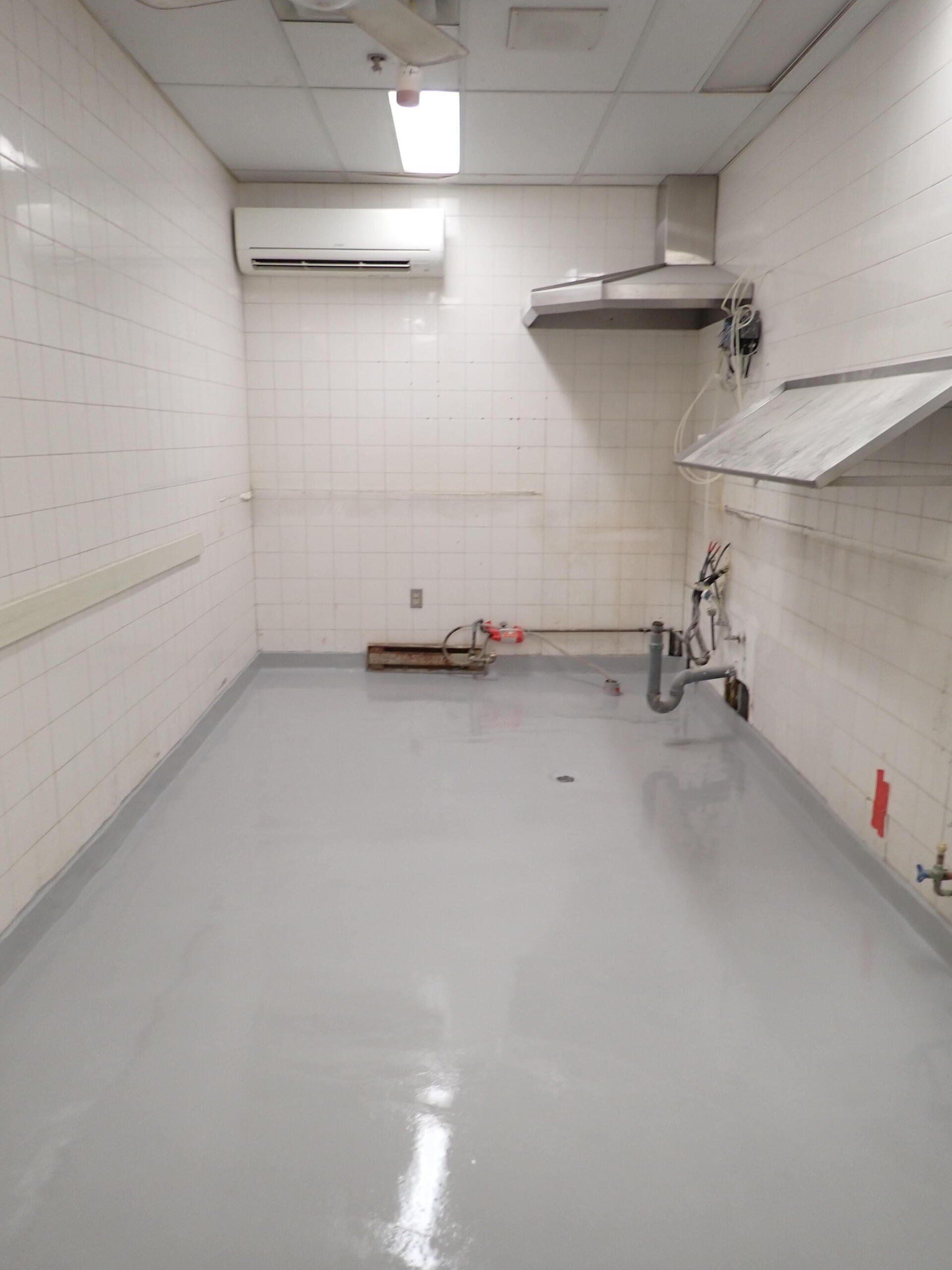 Une cuisine vide avec un ventilateur de plafond et un évier.