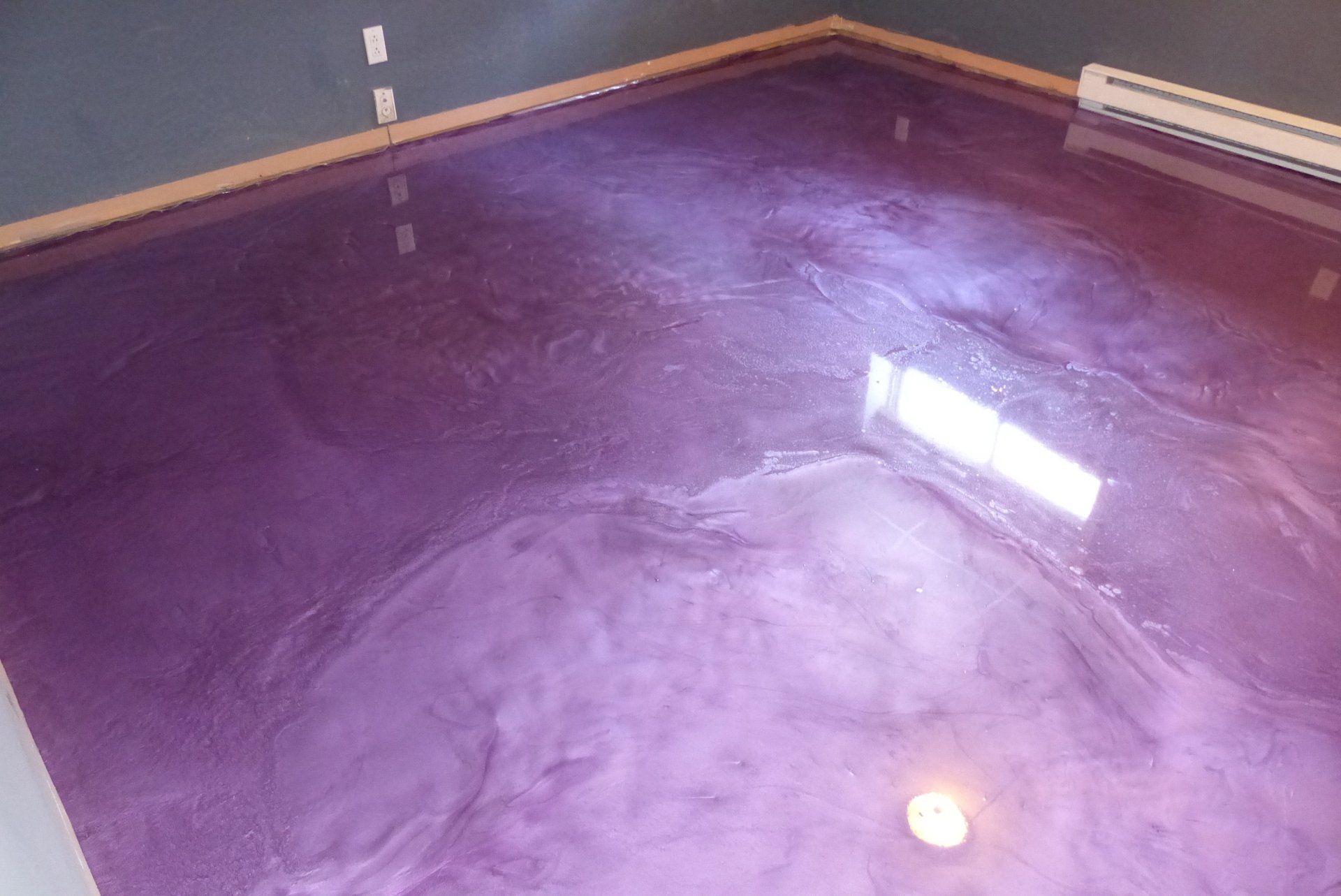 Un sol métallique violet dans une pièce avec une fenêtre.