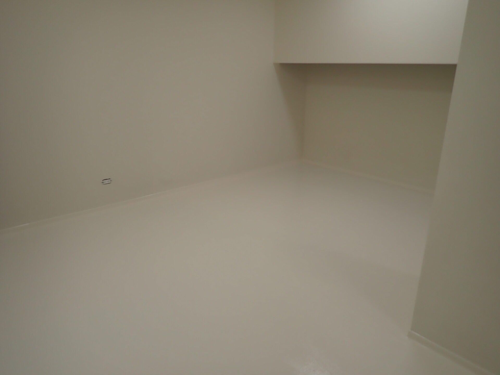 Une pièce vide avec des murs blancs et un sol blanc.