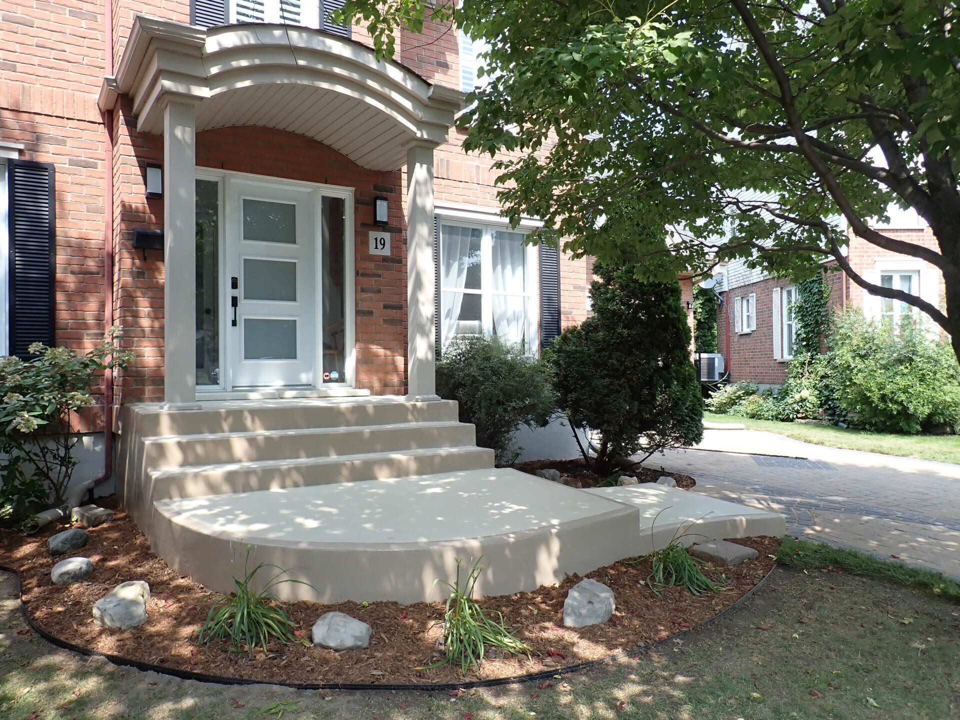 Une maison en brique avec un porche et des escaliers devant