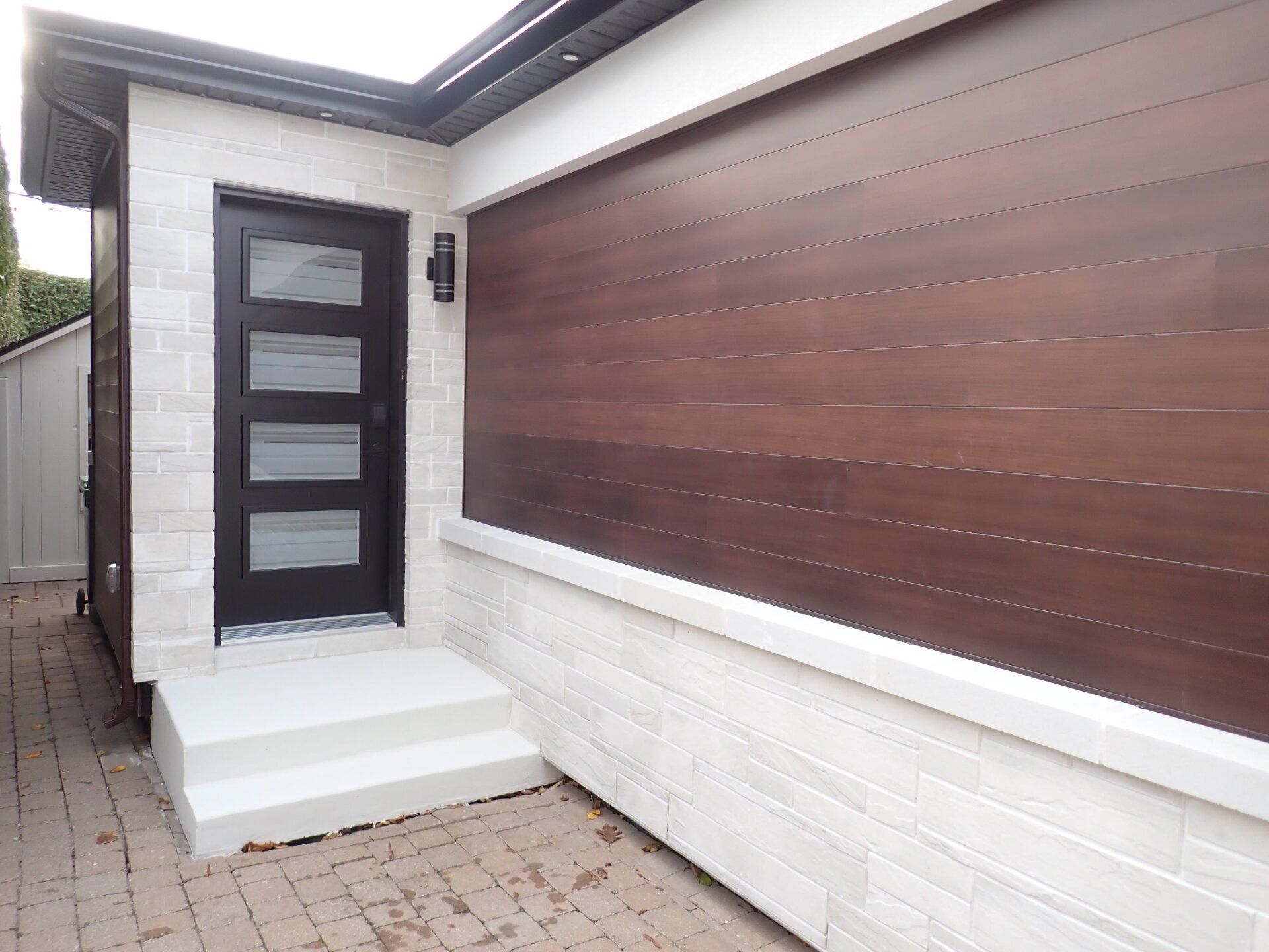 Une maison avec une porte en bois et des marches qui y mènent.