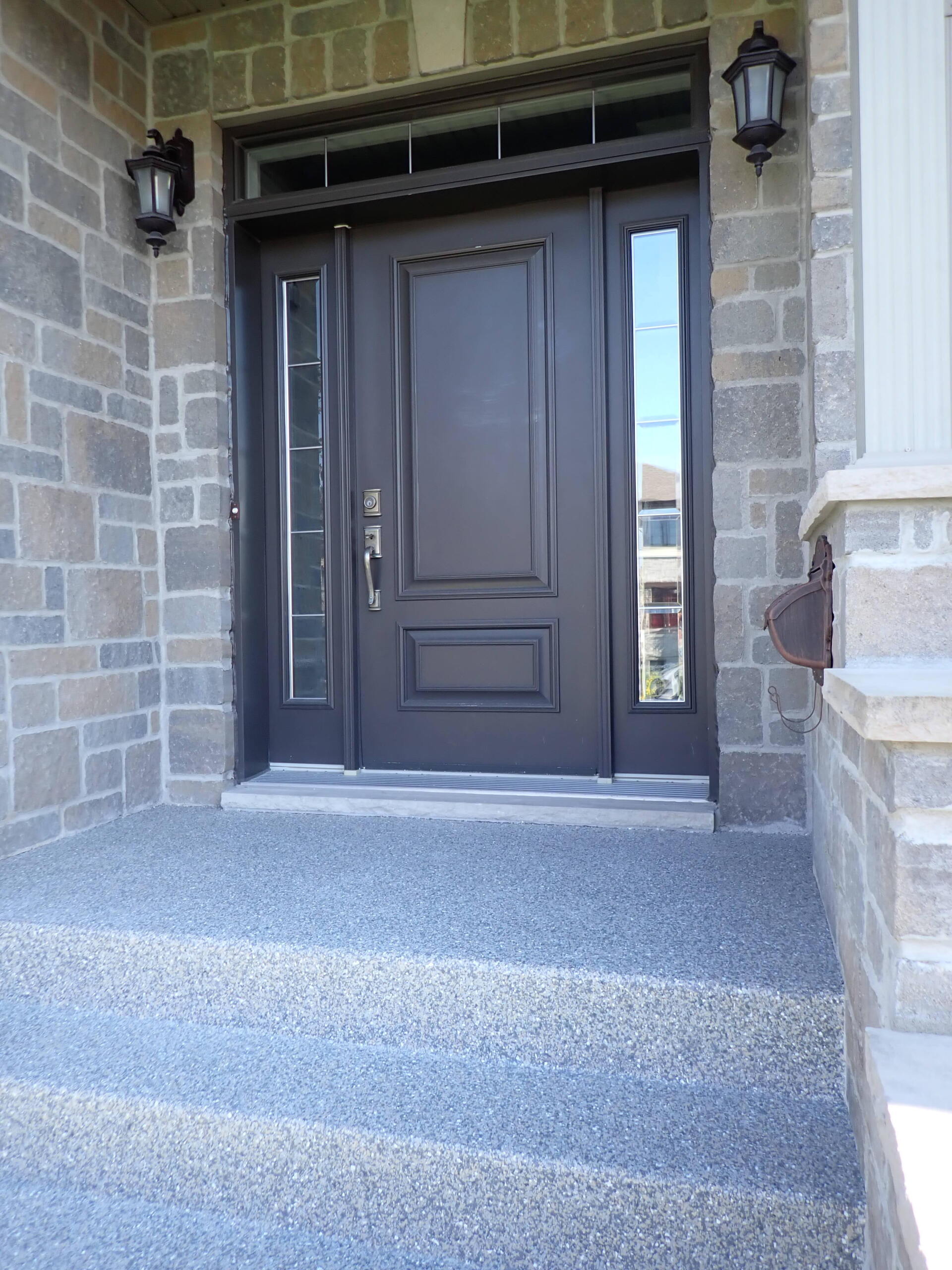 La porte d'entrée d'une maison avec un mur de pierre et des marches