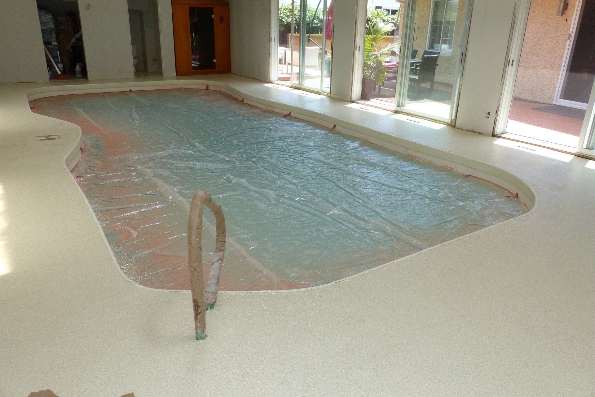 Une grande piscine intérieure est en cours de construction dans une maison.