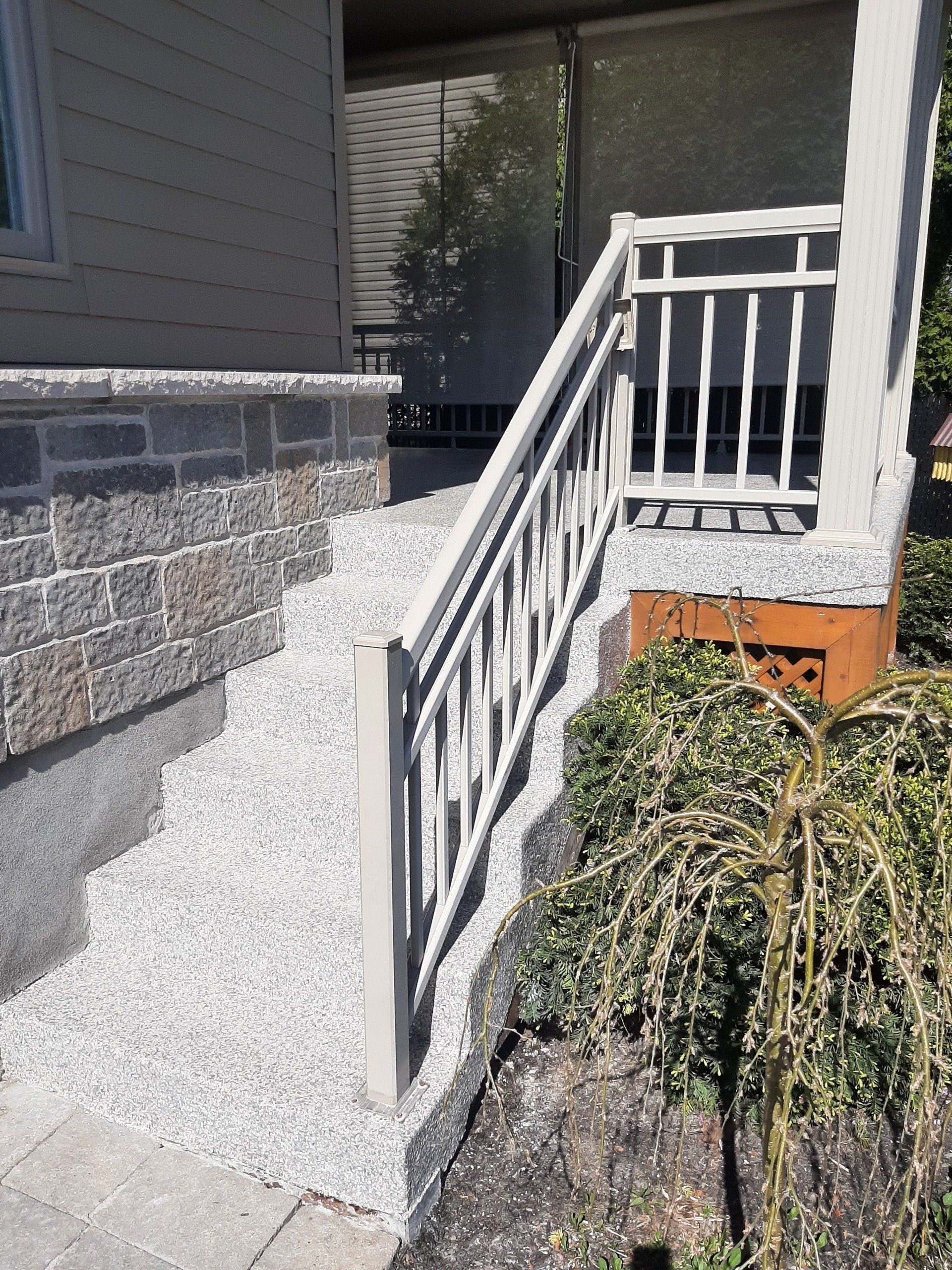 Une balustrade blanche menant au porche d'une maison