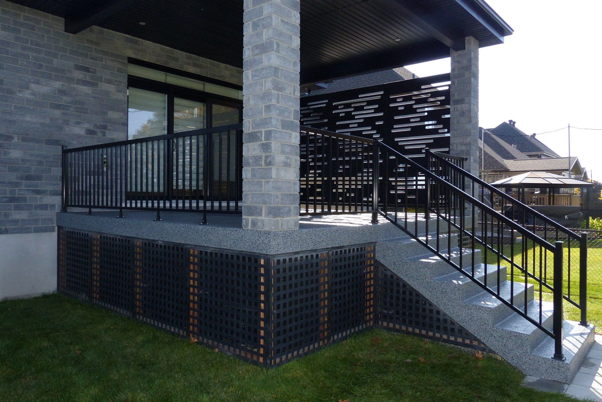 Une maison en brique avec une balustrade et des escaliers noirs