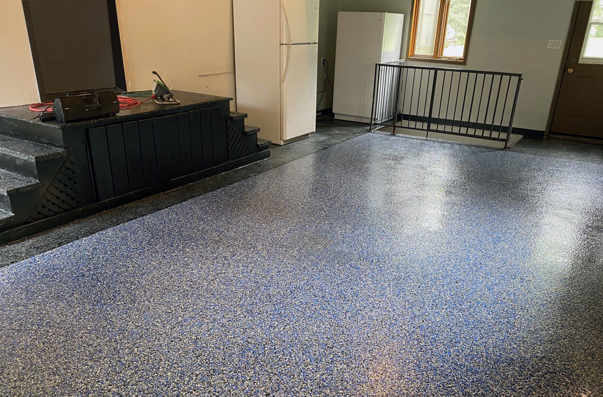 Une pièce avec un sol en béton et des escaliers à l'intérieur.