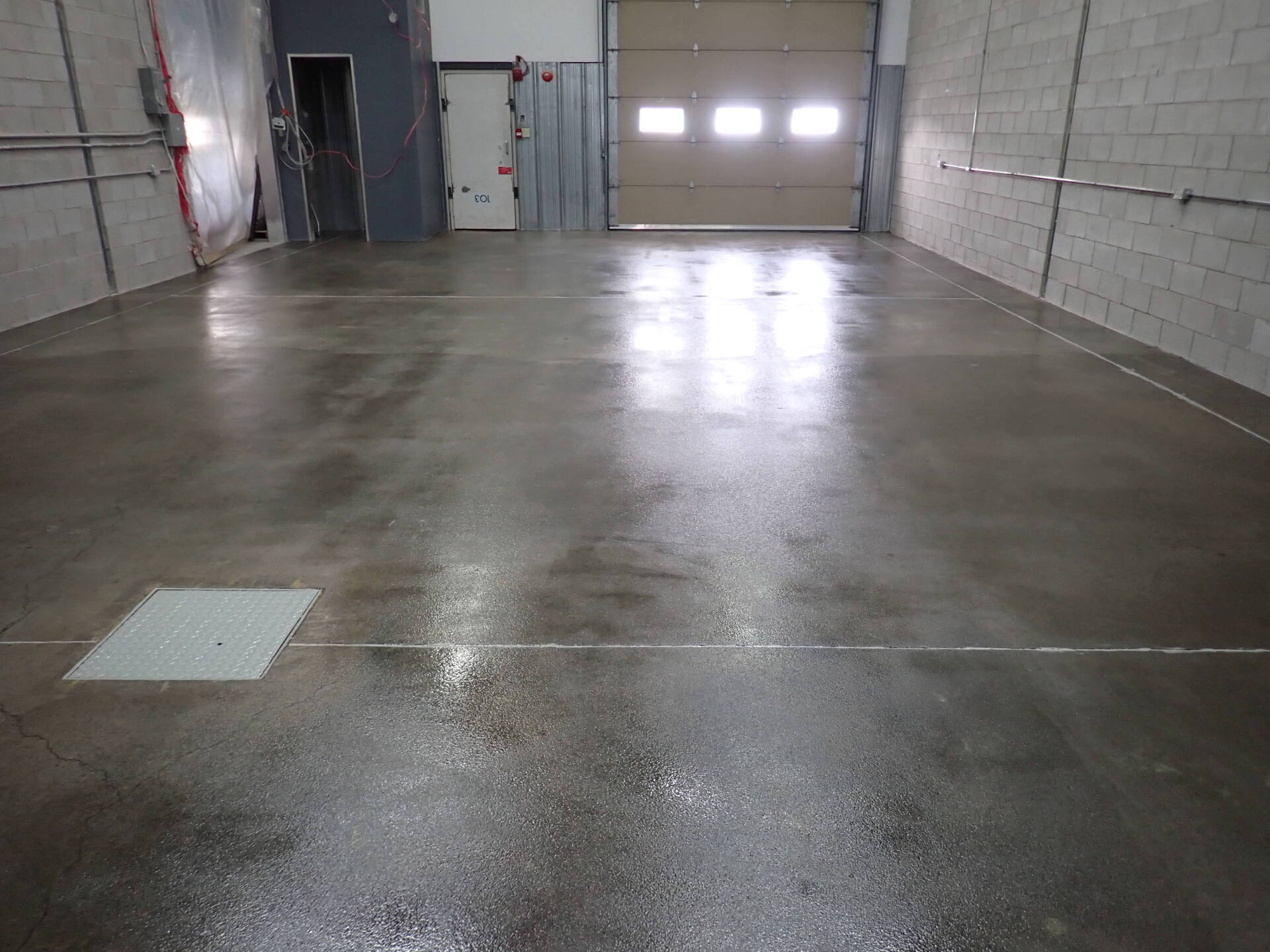 Un garage avec un sol en béton et une porte de garage.