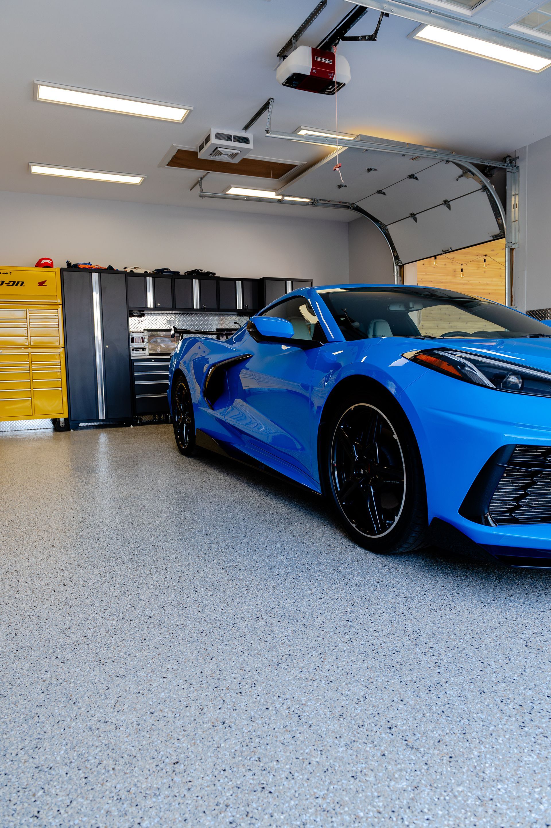 Voiture de sport bleue dans un garage moderne avec des touches de noir.