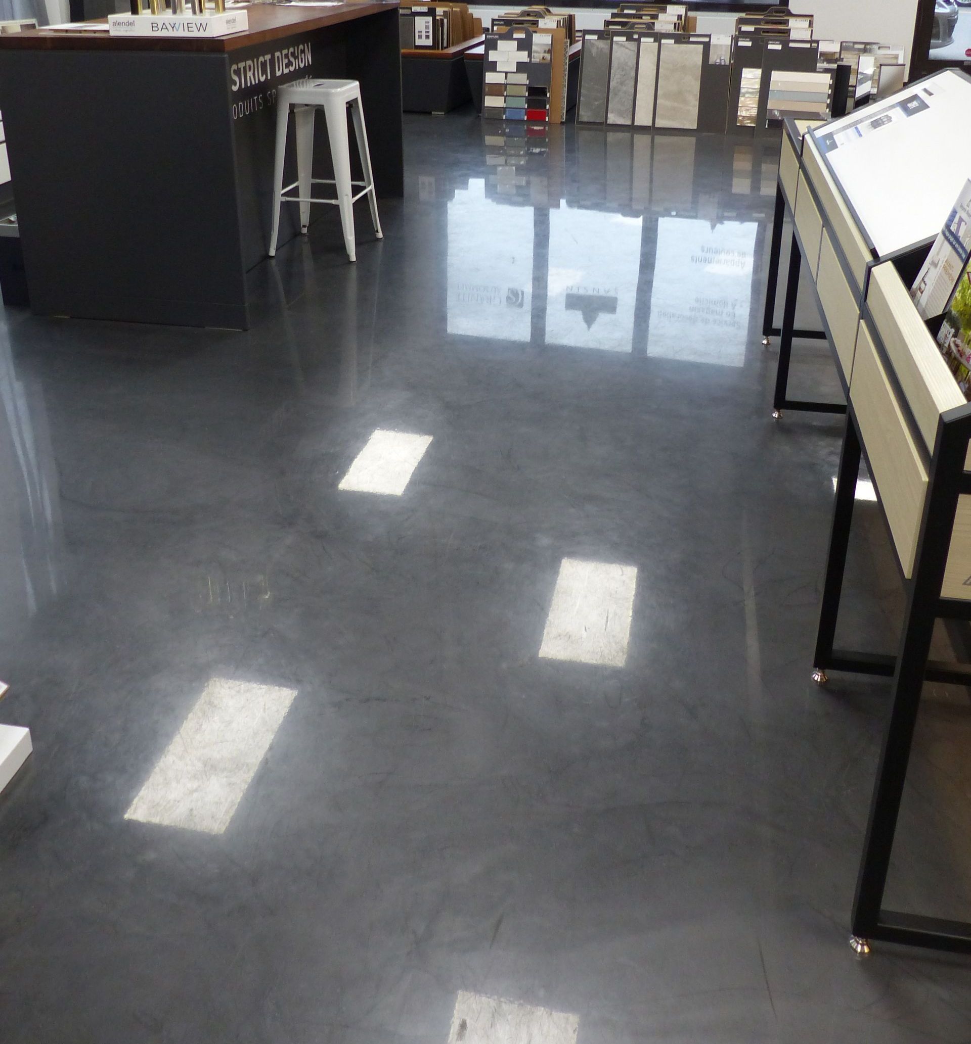 Une pièce avec un sol noir et des tabourets blancs