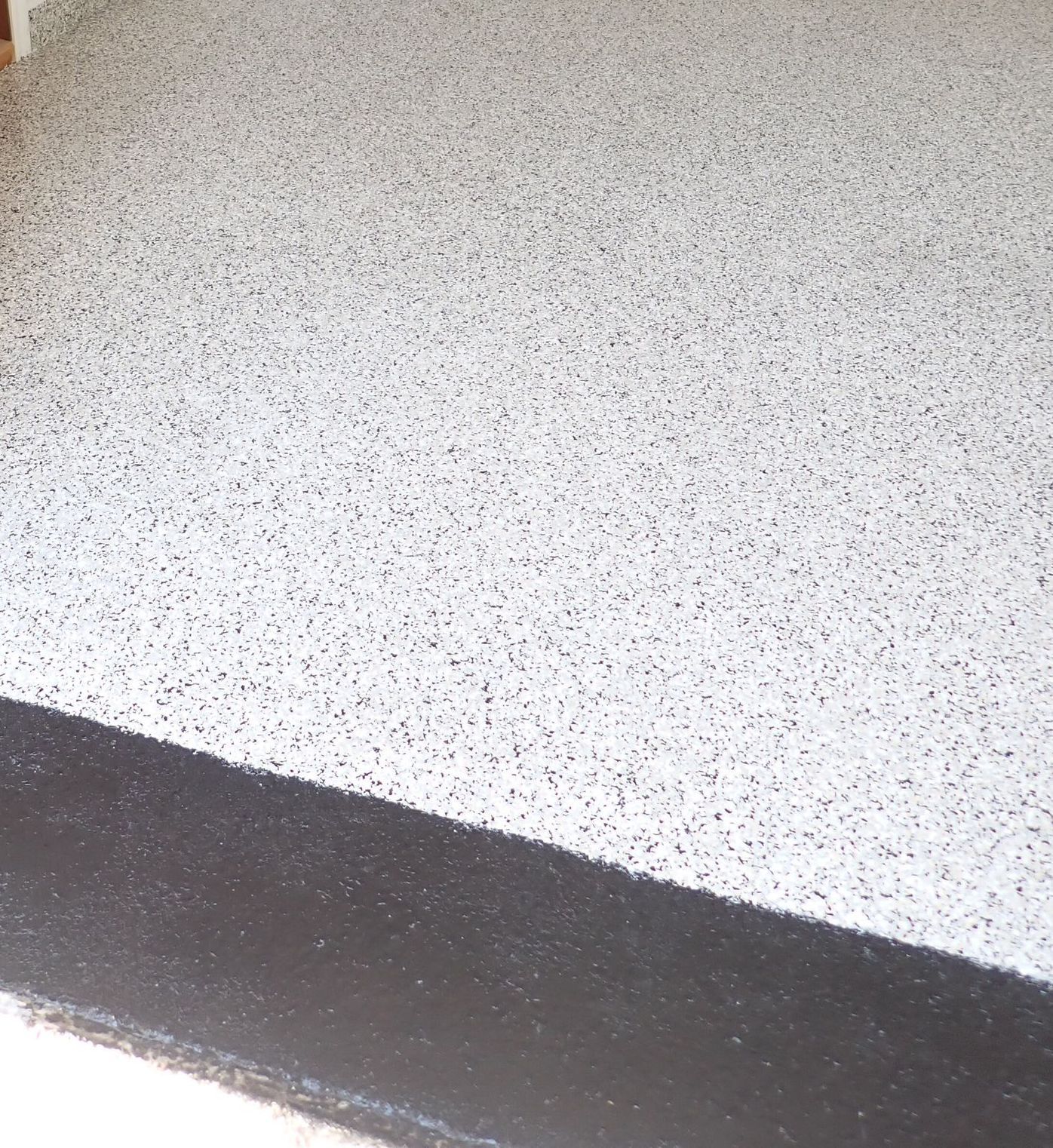 Sol blanc moucheté avec une bordure foncée.