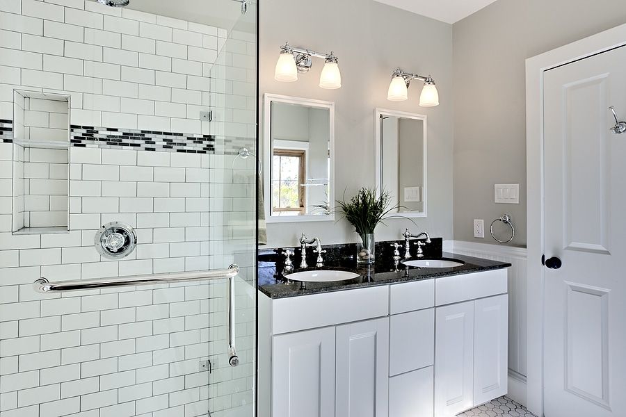 A bathroom with two sinks and a walk in shower.