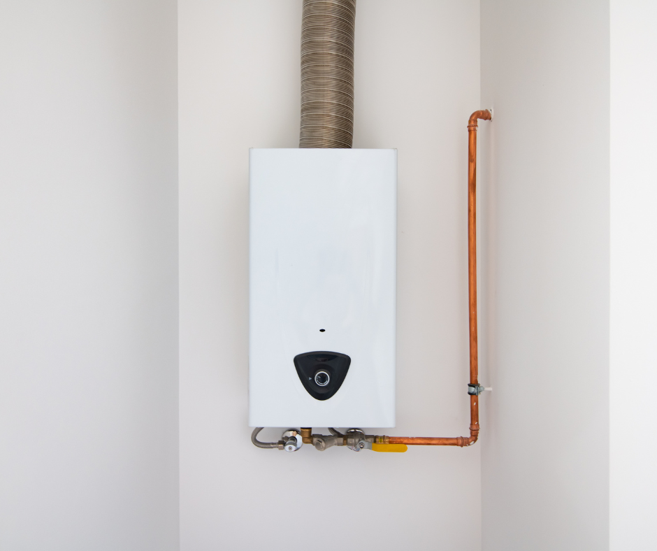 A white water heater is hanging on a white wall next to a copper pipe.