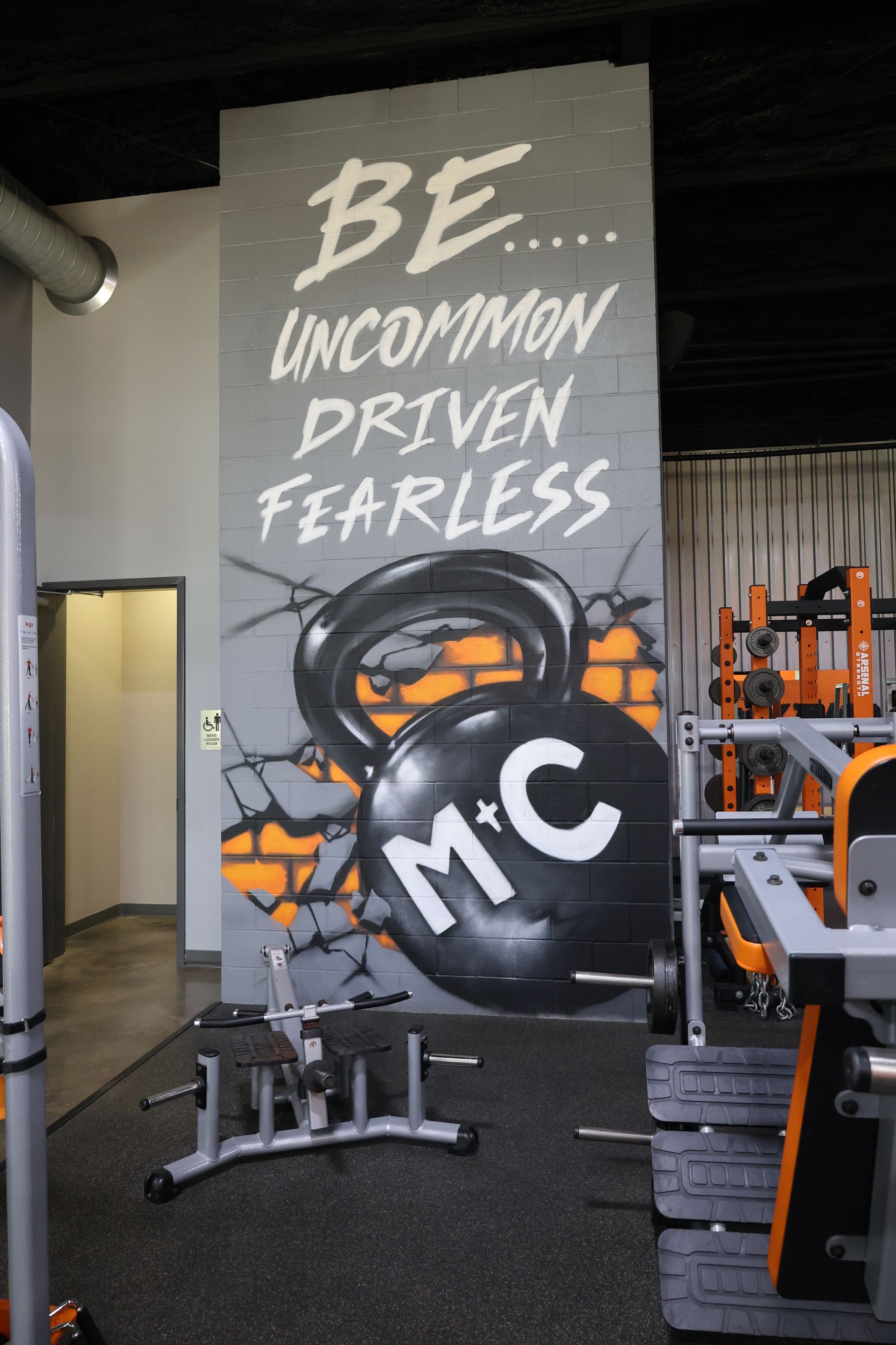 A gym with a mural that says be uncommon driven fearless