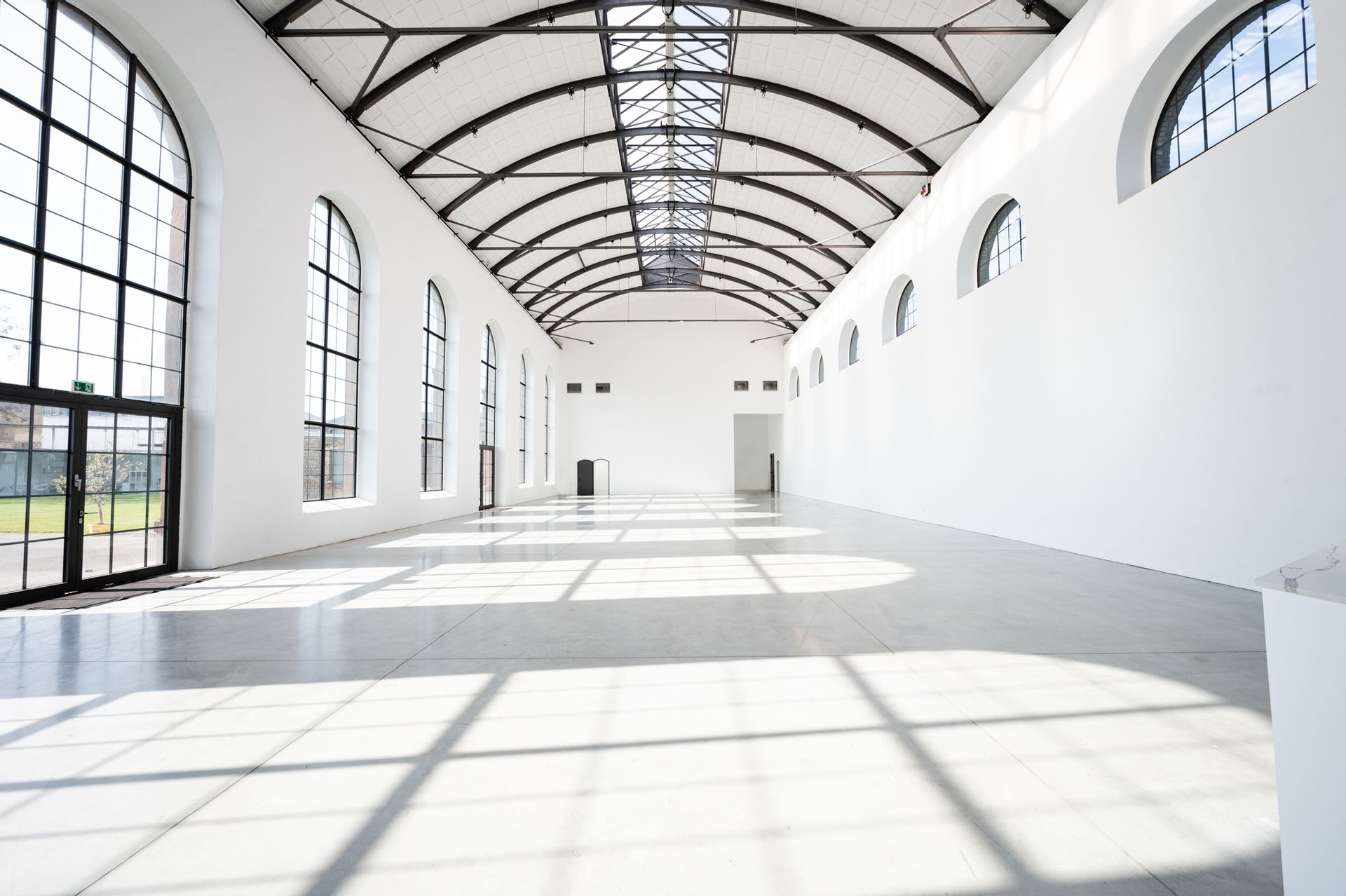 Ein großer leerer Raum mit vielen Fenstern und gewölbten Decken