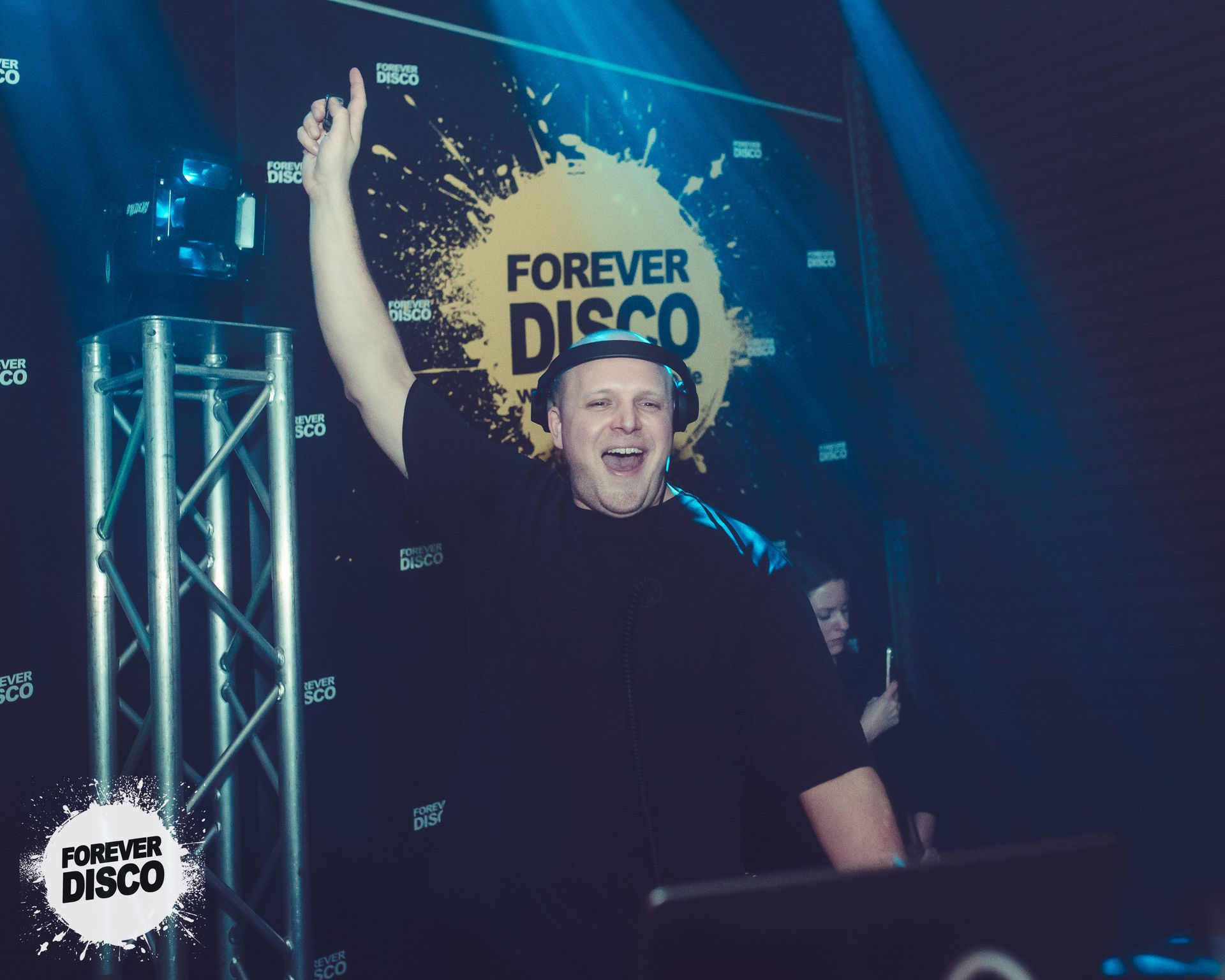 Ein Mann steht vor einem Schild mit der Aufschrift „Forever Disco“