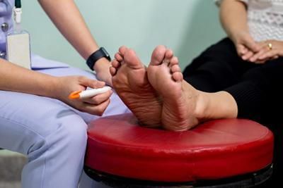A nurse is writing on a patient 's foot with a marker.