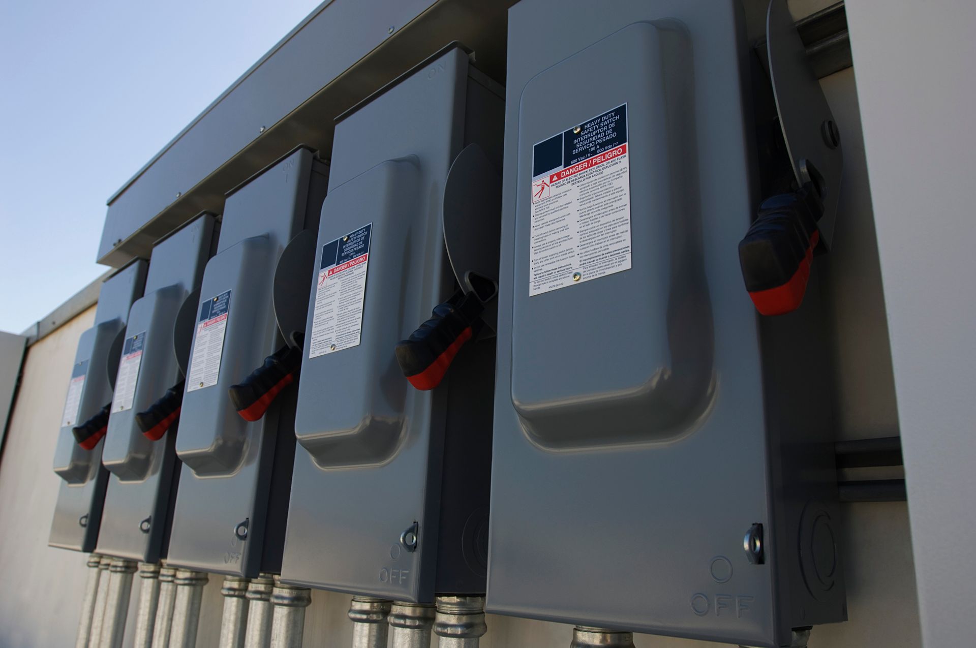 Close-up view of multiple electrical breaker boxes arranged neatly within a solar power plant facility.