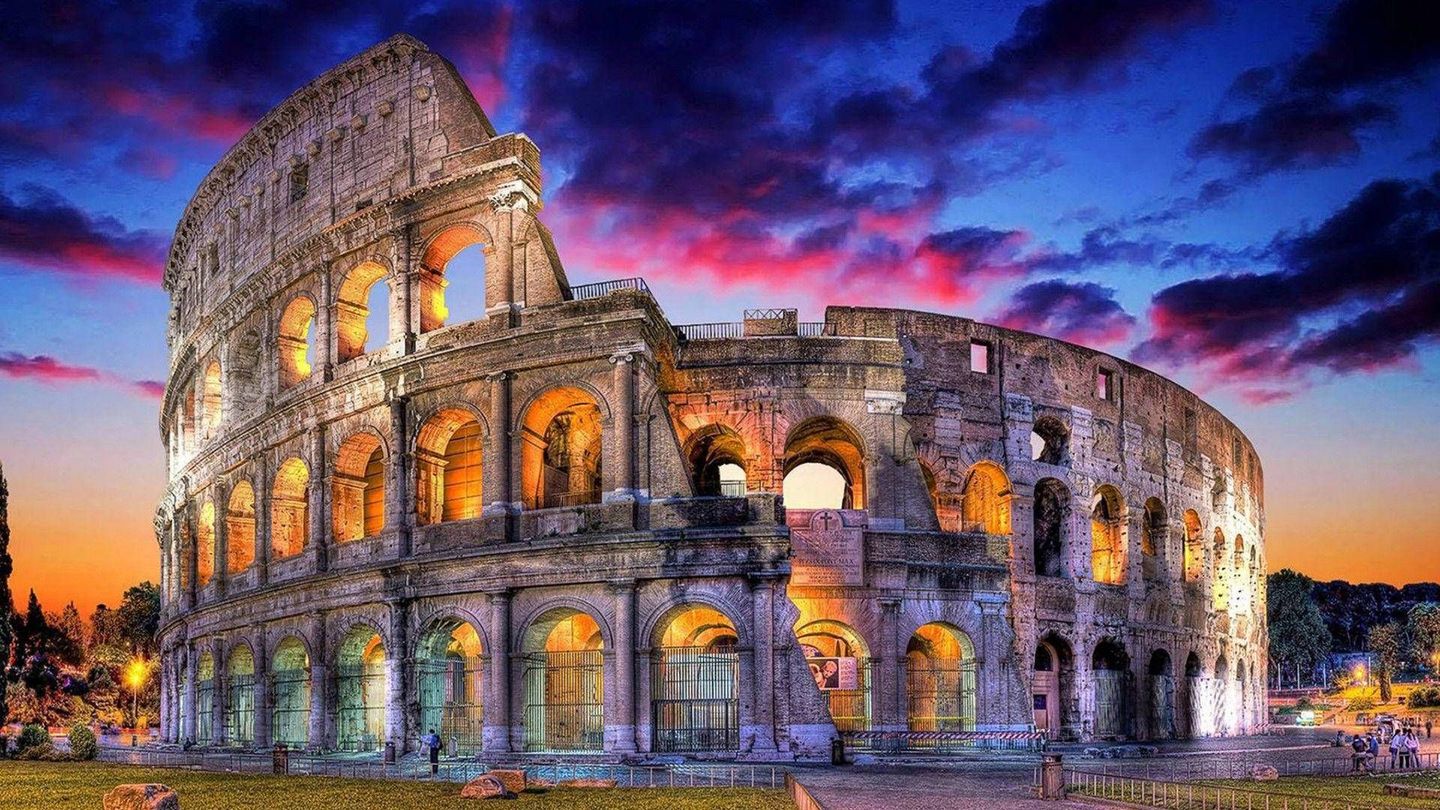 Twilight view over Rome's Colosseum, glowing with lights, a must-see for Italy travel.