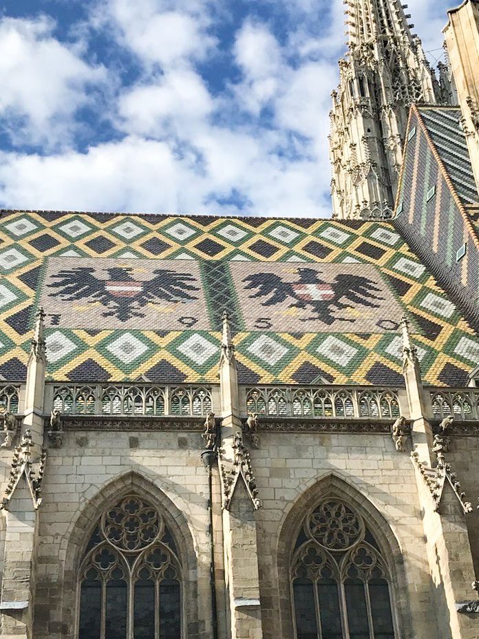 View of St. Stephen's Cathedral roof in Vienna, Austria, with the Habsburg double-headed eagle emblem on tiled roof.