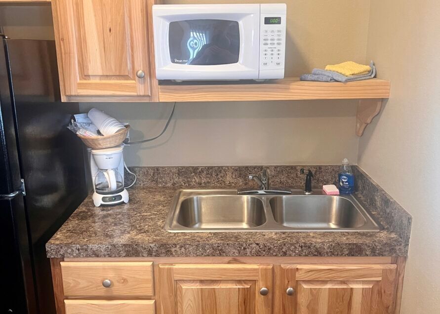 Kitchen with a sink, microwave, coffee maker, and cabinets.