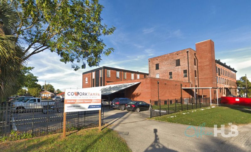 A large brick building with cars parked in front of it.