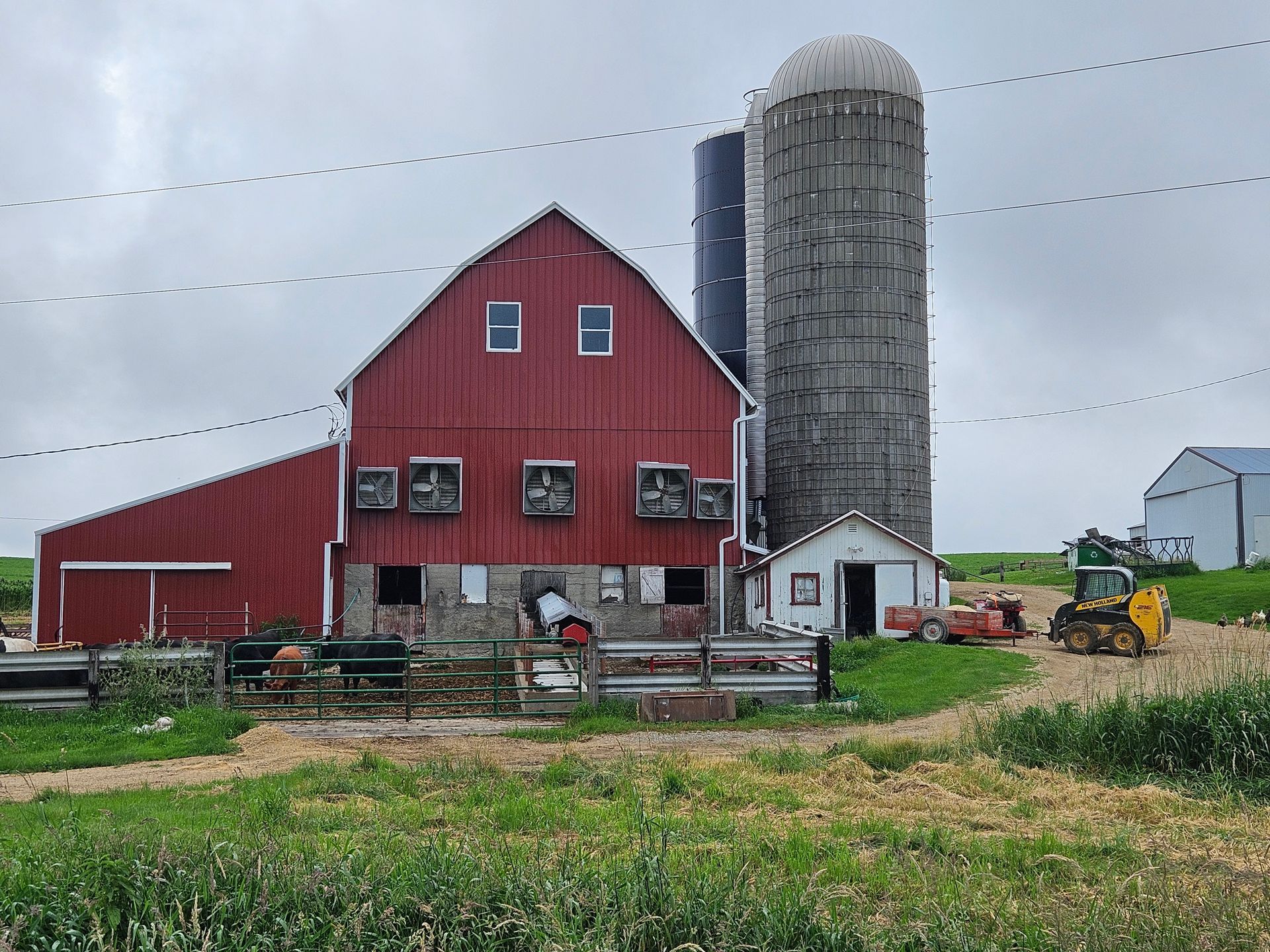 A red barn with a silo in the background