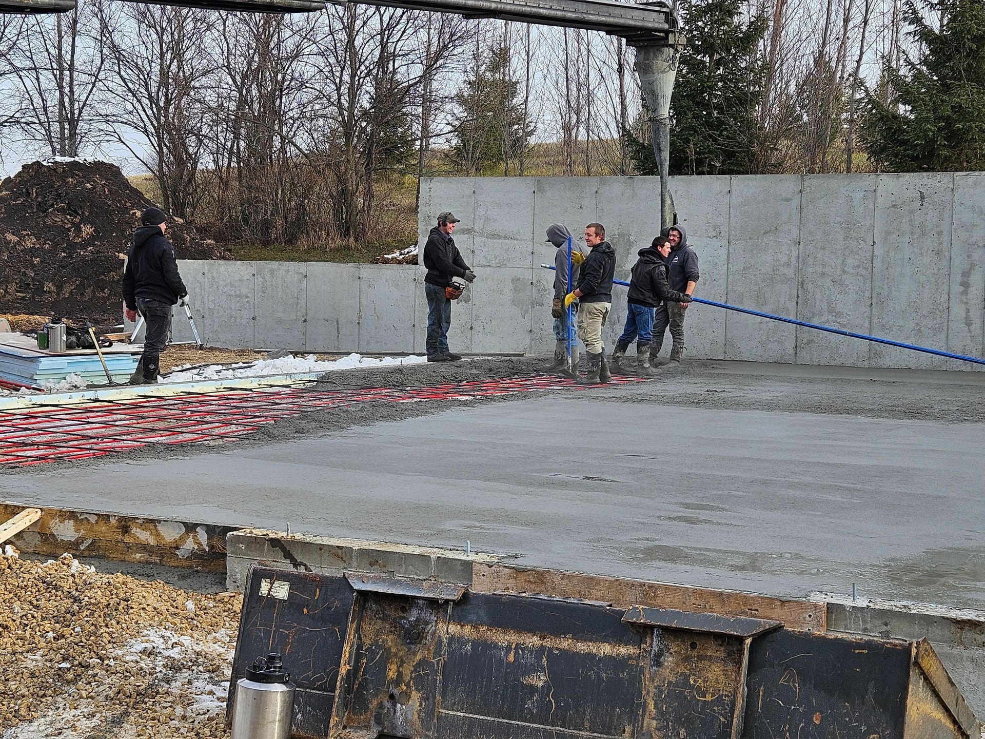 A group of construction workers are working on a concrete floor.