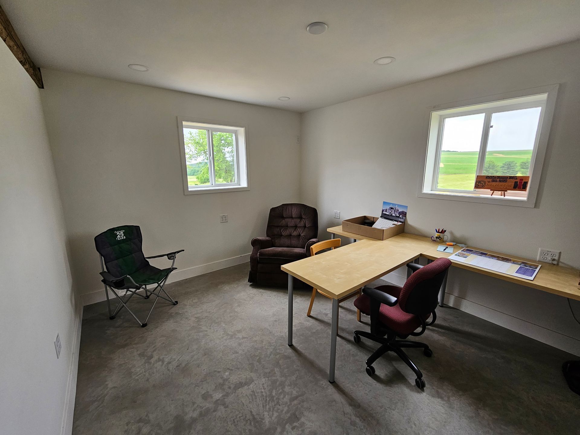 A room with a desk , chair , and window.