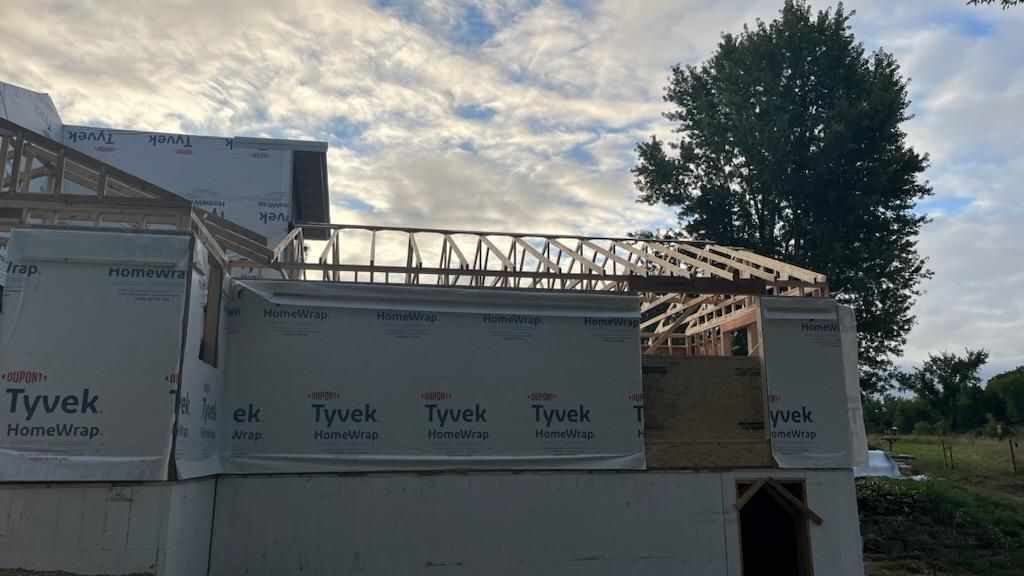 A building under construction with a tree in the background.