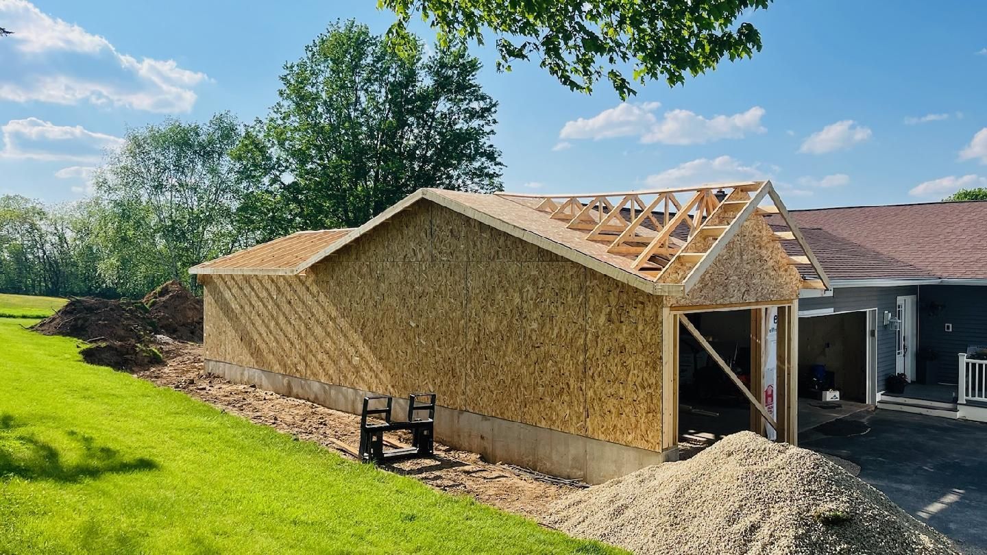 A garage is being built in the backyard of a house.