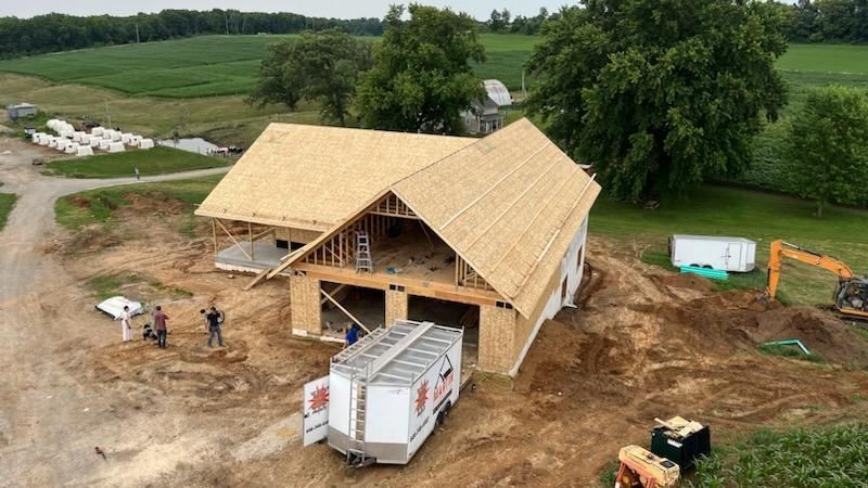 An aerial view of a house being built on a dirt field.