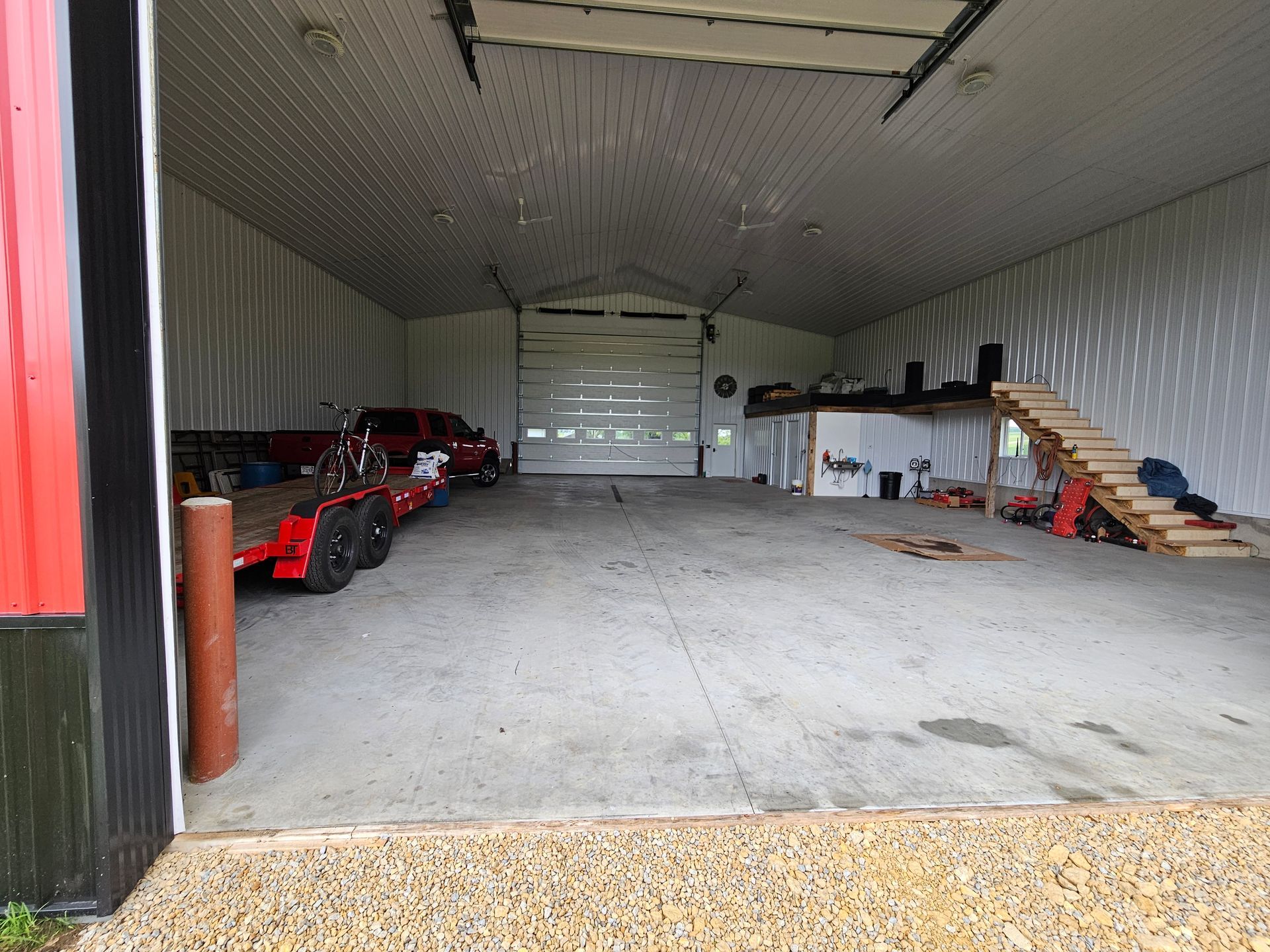 An empty garage with a red truck on a trailer