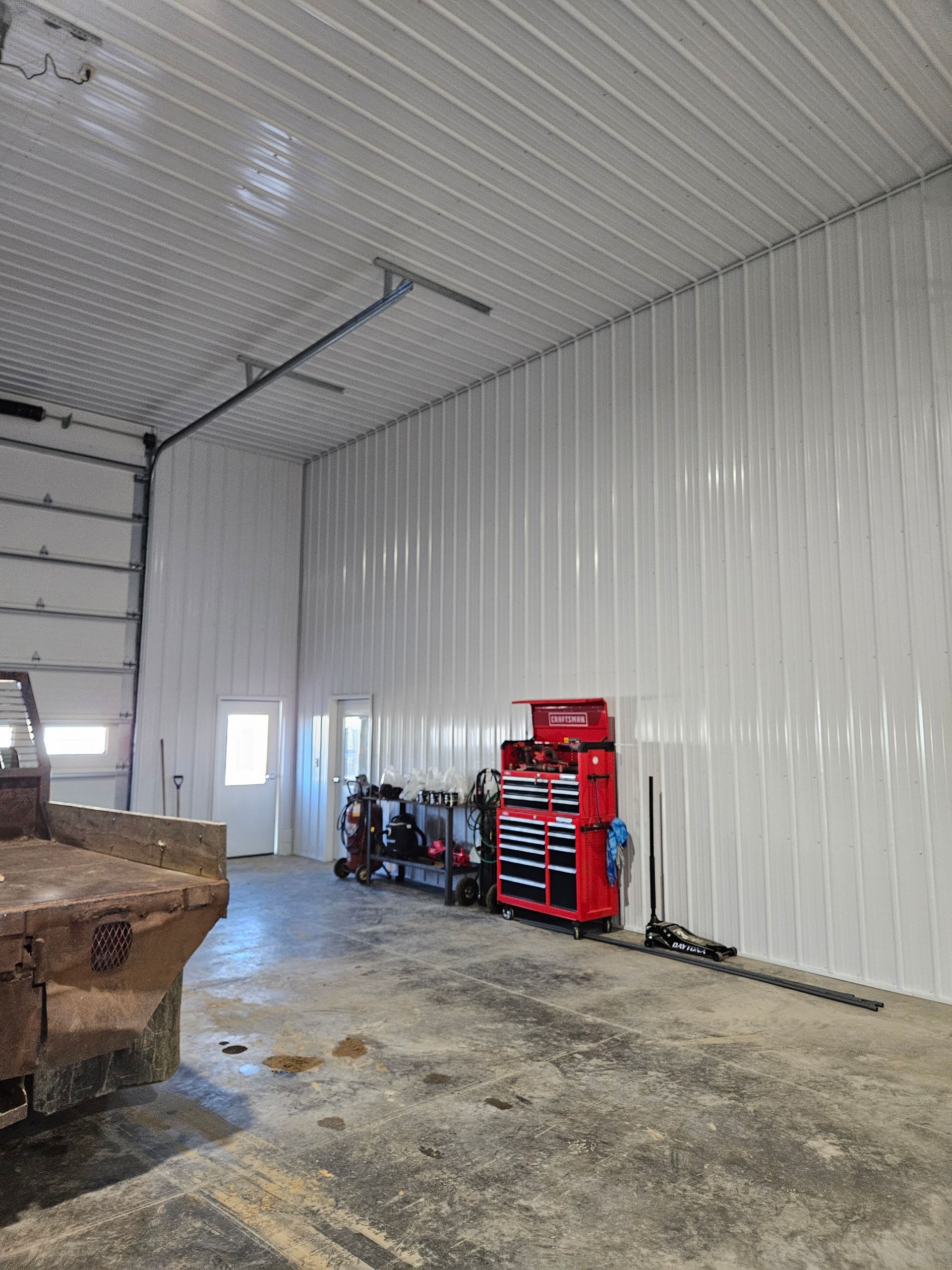 A truck is parked in a garage with a red toolbox.