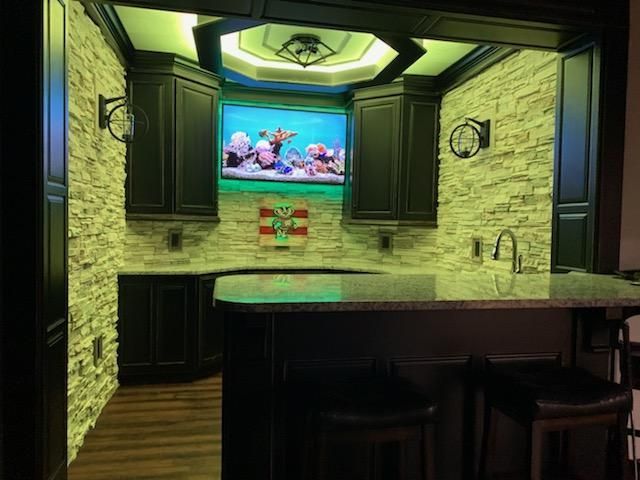 A kitchen with a bar and a television on the wall.