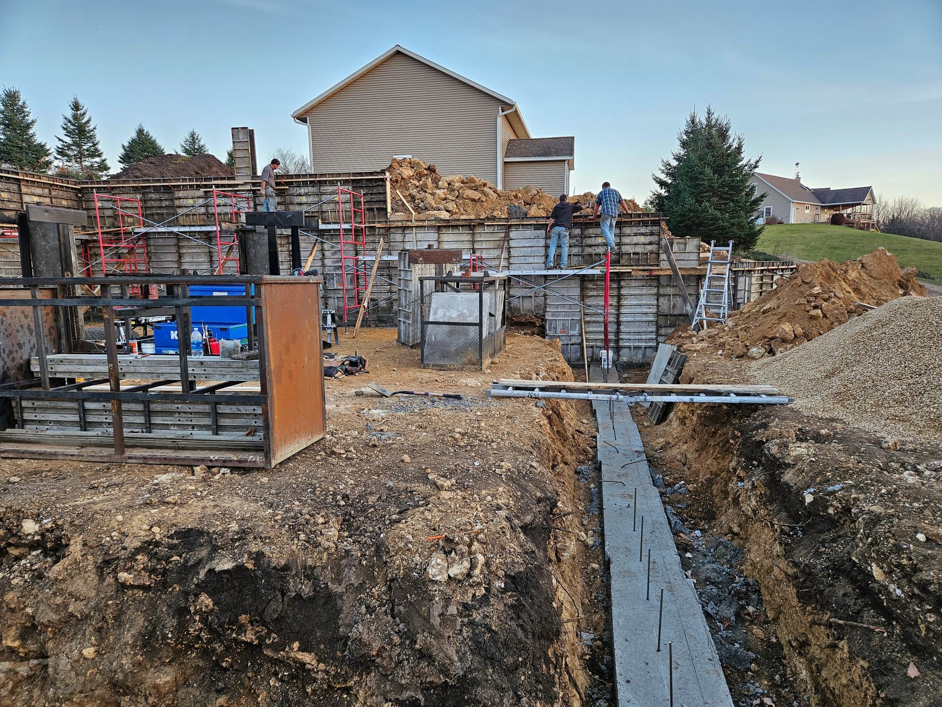 A construction site with a house in the background.