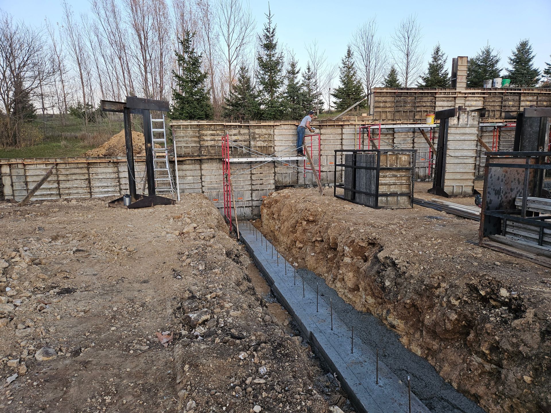 A construction site with a lot of dirt and trees in the background.
