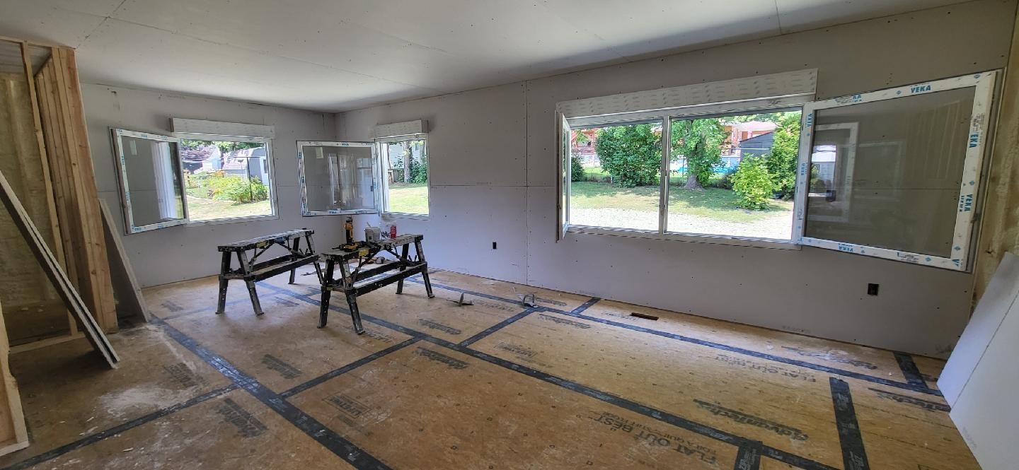 A room with a lot of windows and a wooden floor.