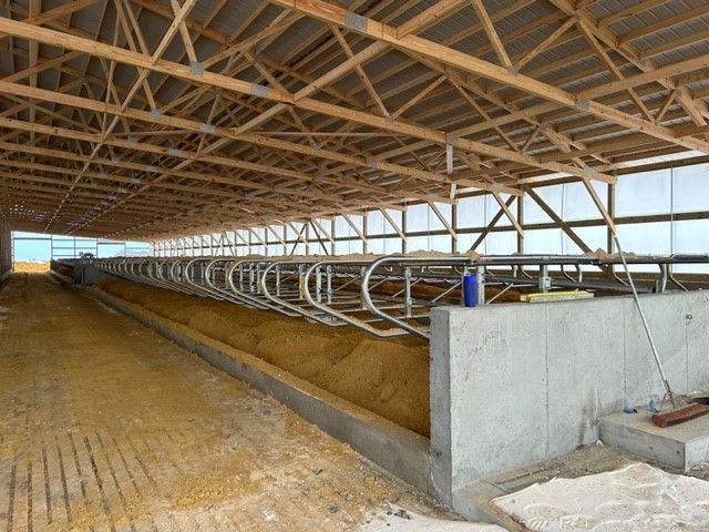 A large barn with a wooden roof and a lot of windows