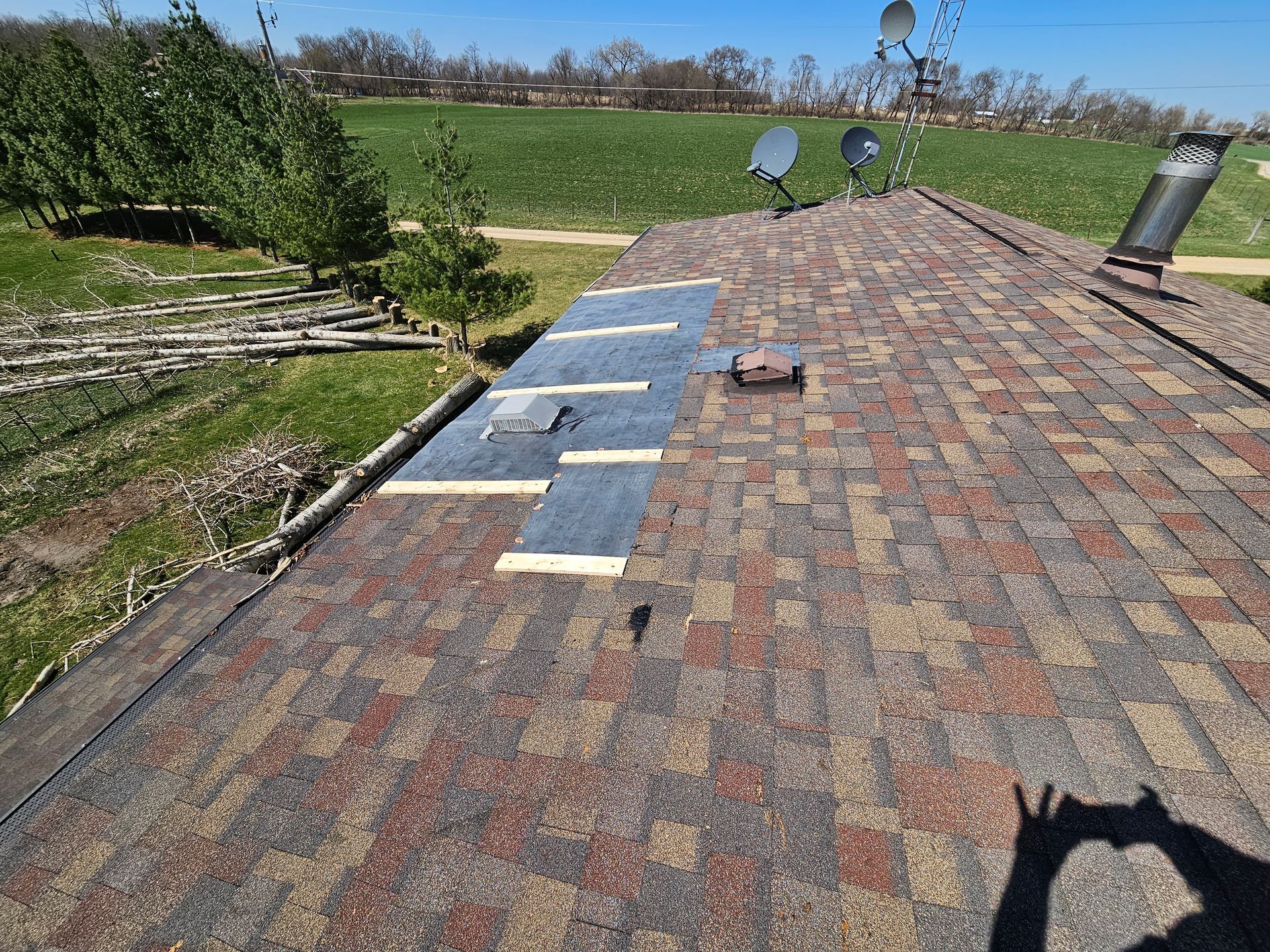 Roof with missing and exposed shingles, in need of repair. Daytime, outdoor setting.
