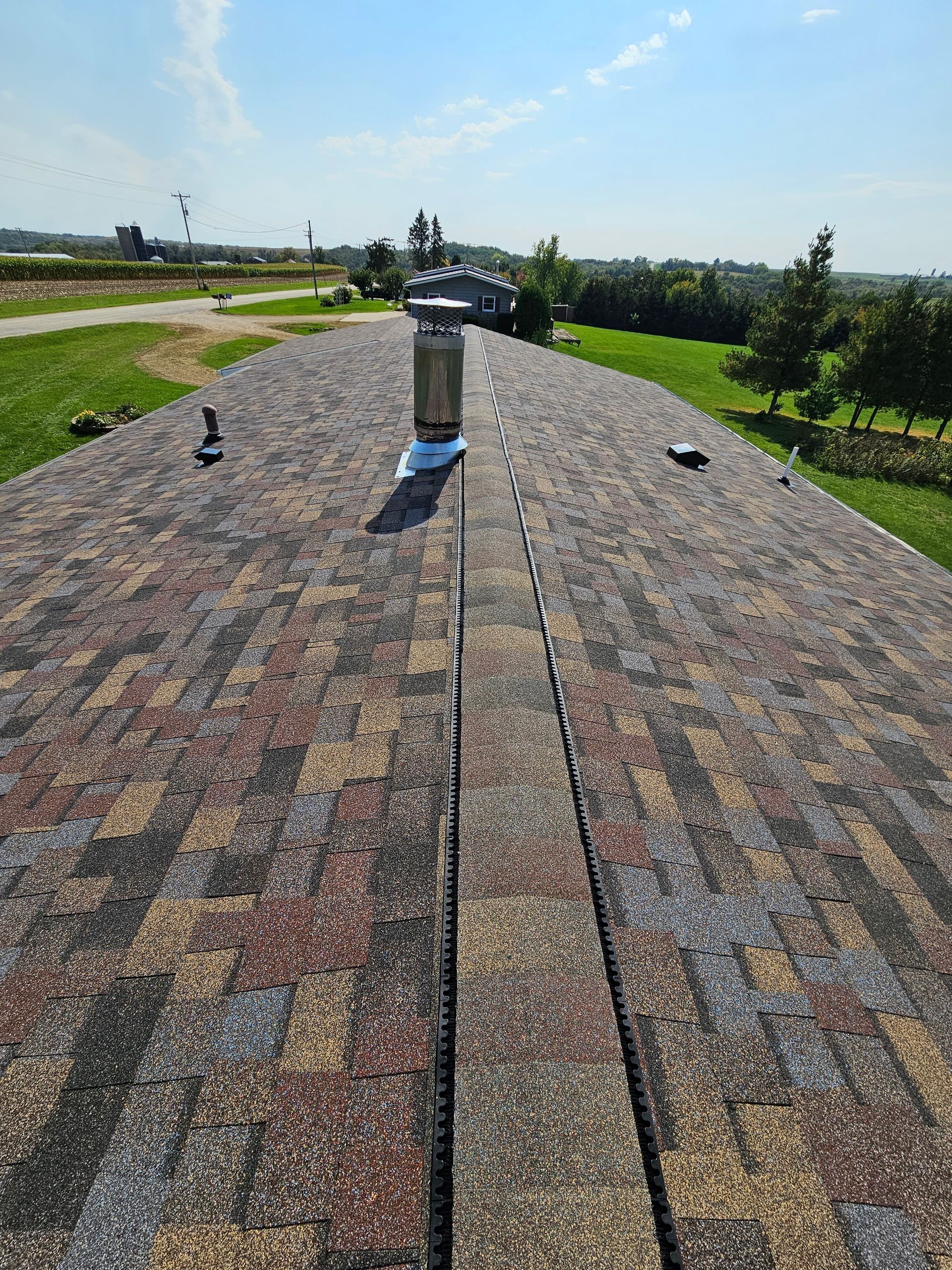 A roof with shingles and a chimney on it.