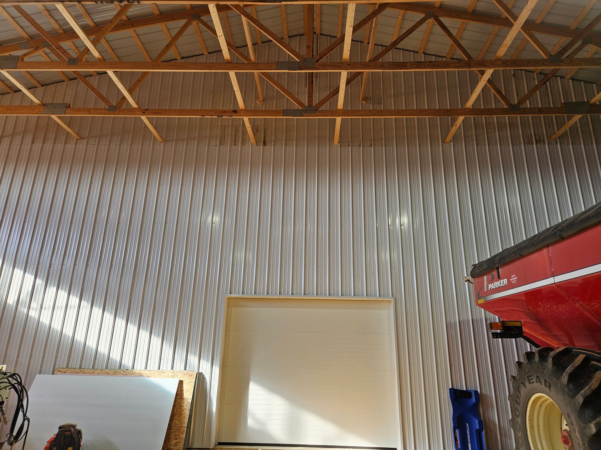 A red and white tractor is parked in a barn