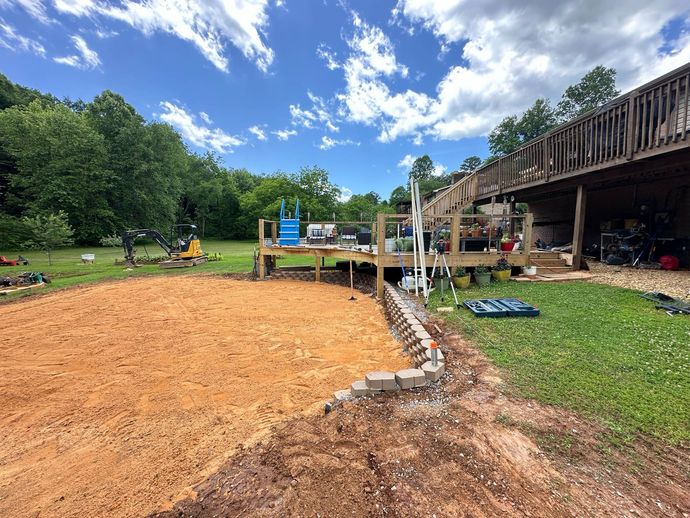 A wooden deck is being built in the backyard of a house.