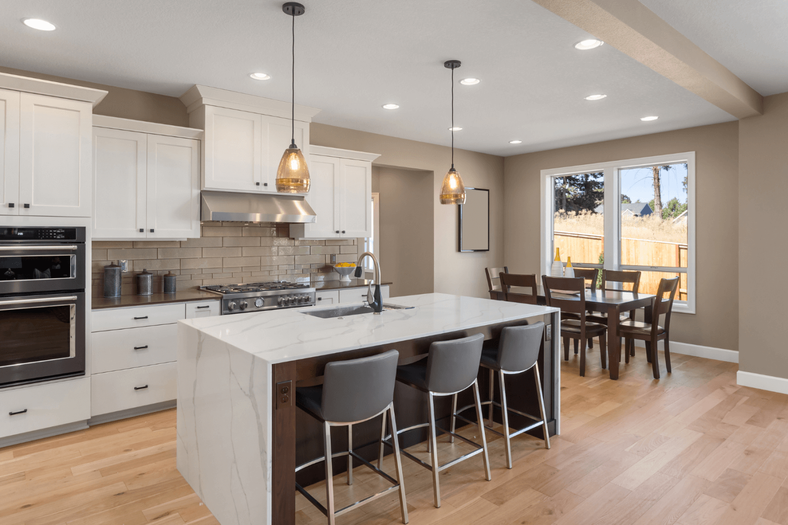 A kitchen with a large island in the middle and a dining room.