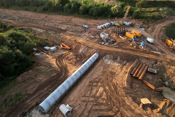 An aerial view of a construction site with pipes and trucks.